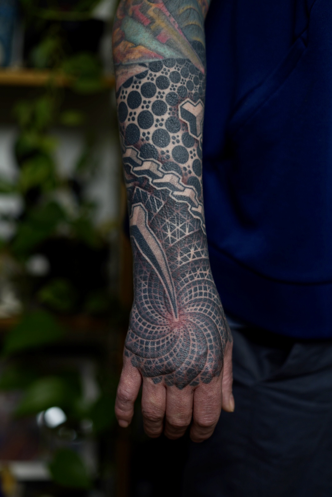 Geometric blast over hand and forearm tattoo by Steve Sherick